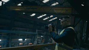 a man in a yellow vest holding a camera